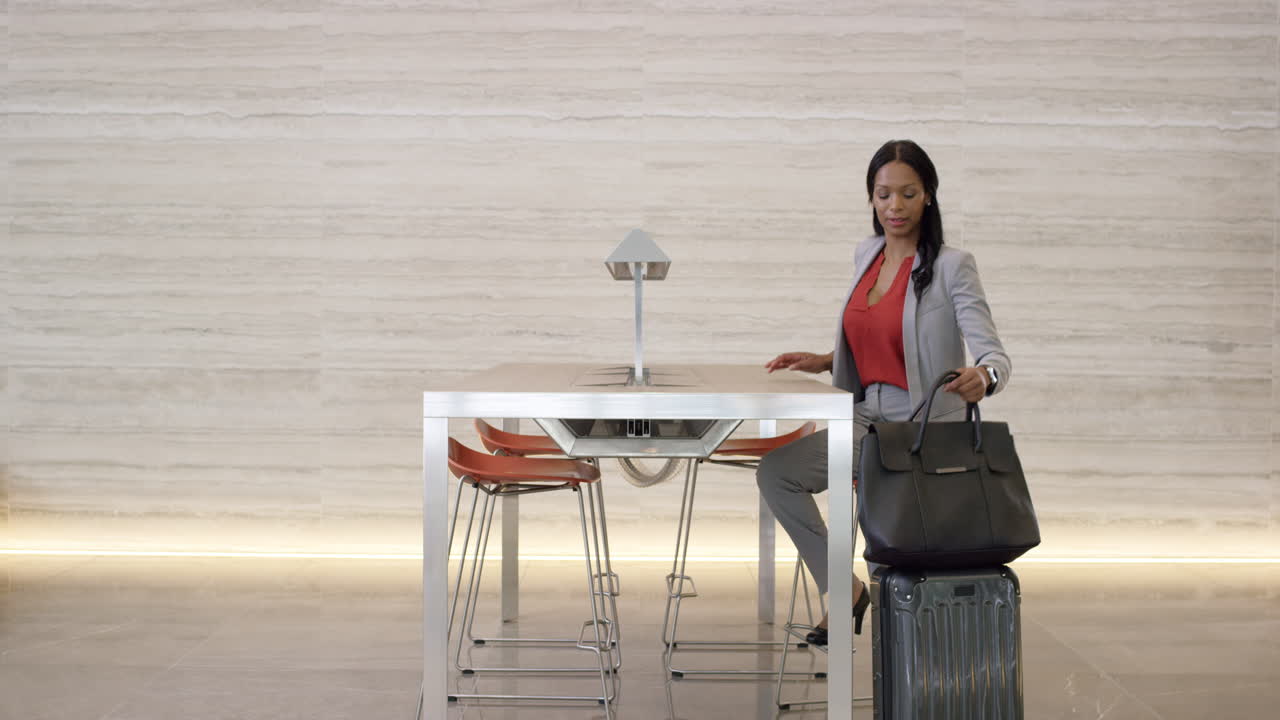 Bella e intelligente donna d'affari afroamericana che lavora al laptop nella lobby.
