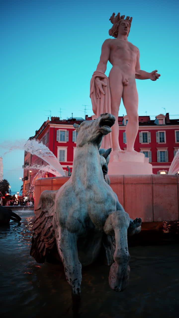 Nice, France - October 8, 2024: Apollo statue in the Fontaine du Soleil at Place Massena in the evening. Vertical