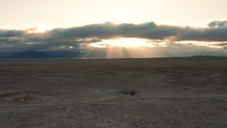 morning sunbeams behind rustic cattle corral in desert ranch landscape