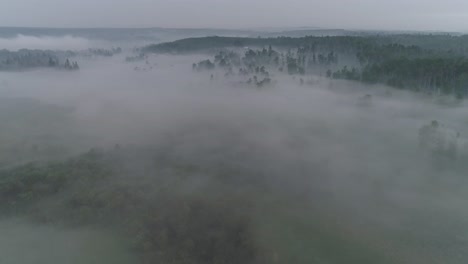 Low-visibility-aerial-view-flying-through-fog-and-smoke-to-reveal-an-Alberta-country-farm-location