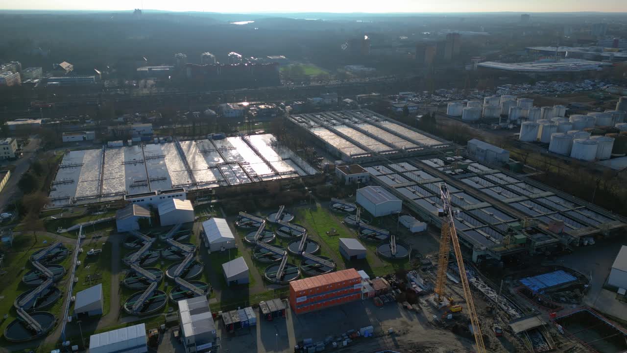 Wastewater treatment plant purifying urban water showing sedimentation tanks, aeration tanks and clarifiers. Unique aerial view flight static tripod hovering drone