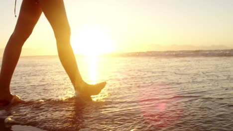 woman walking on the beach during sunset