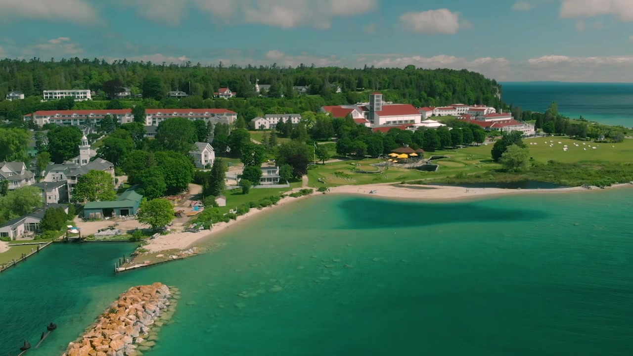 Ilmakuva viehättävästä rannikkokaupungista ja rannasta turkoosilla vedellä.