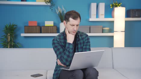 hombre usando una computadora portátil mientras está pensativo y confundido.