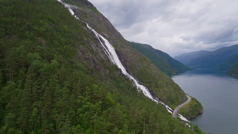 side aerial view of impressive langfoss falls cascading down rocky mountainside