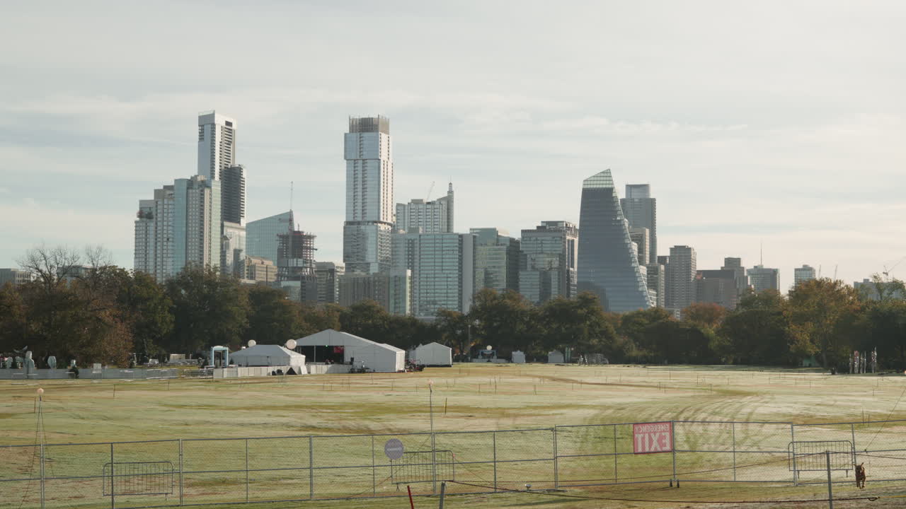 아스틴 시내, 텍사스 시의 스카이라인은 zilker 파크에서 아름다운 아침  ⁇ 빛과 함께 슬로우 모션으로 달리는 개와 함께