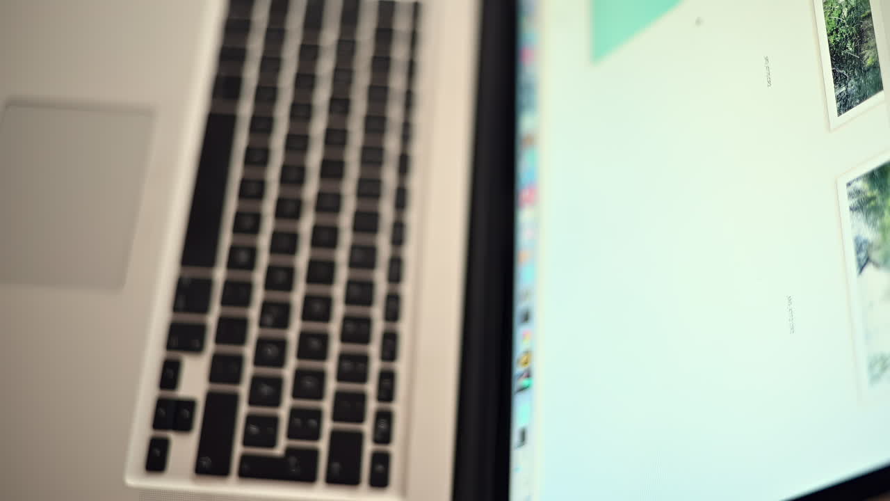 A laptop is open on a desk, showing a workspace with a soft light. The focus is on the keyboard and part of the screen, revealing a calm atmosphere for productivity