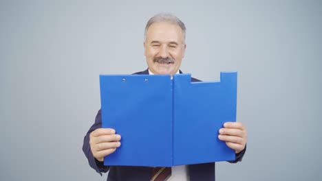 businessman looking from behind files.