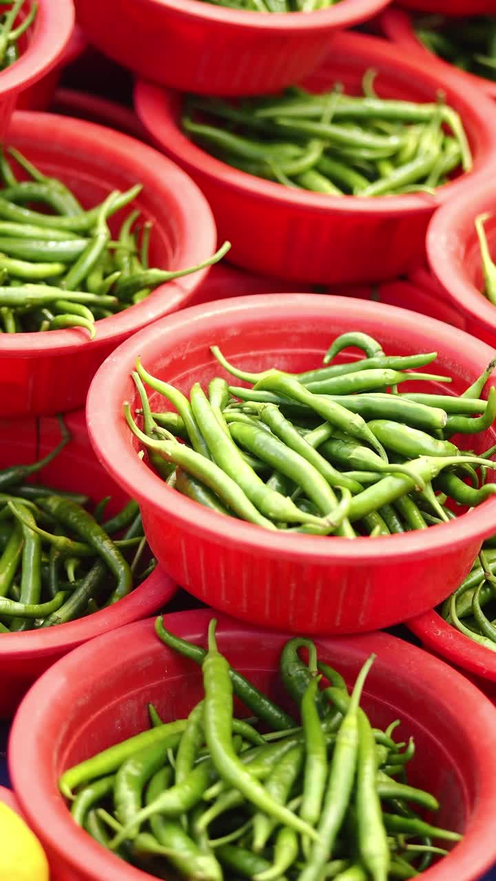 Green Chili Peppers in Red Bowls at a Market