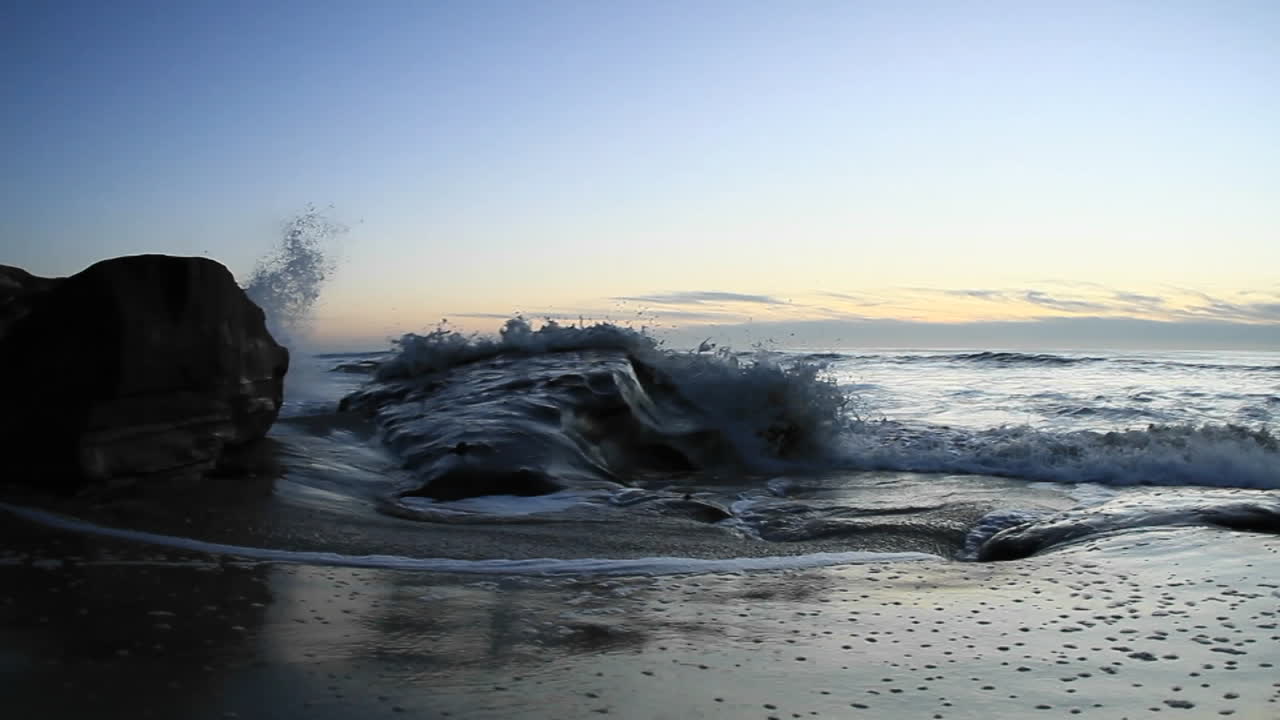 휴대용 카메라는 일몰 직후 해변으로 밀려오는 파도를 포착합니다 1