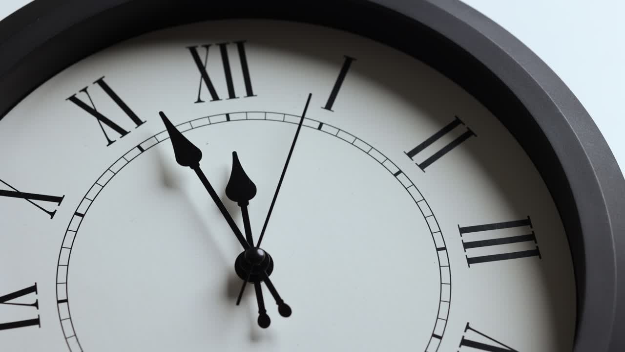 Filmato in time-lapse. Grande orologio da parete bianco. Imposta l'ora alle 12:00. La lancetta rossa dei minuti continua a girare. Numeri romani.