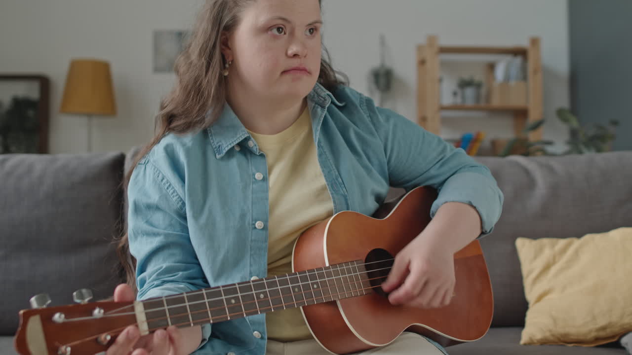 Woman with Down syndrome playing ukulele at home