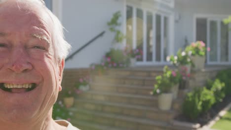 portrait of happy caucasian senior man on sunny day in garden