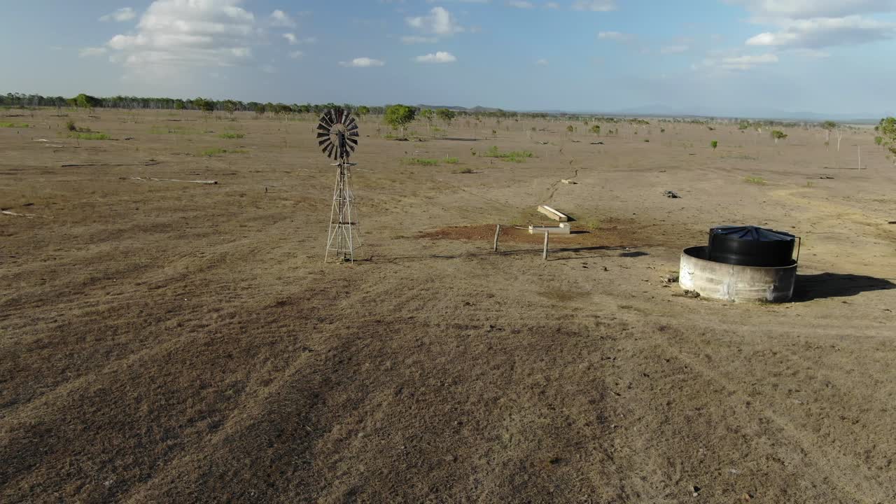 호주의 황폐한 들판에 있는 오래된 풍차와 탱크 주위를 공전하는 공중 궤도