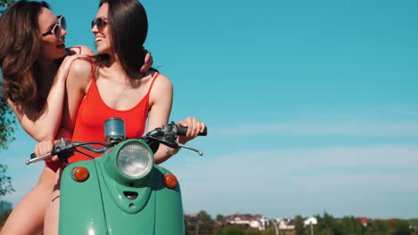 dos mujeres en un scooter