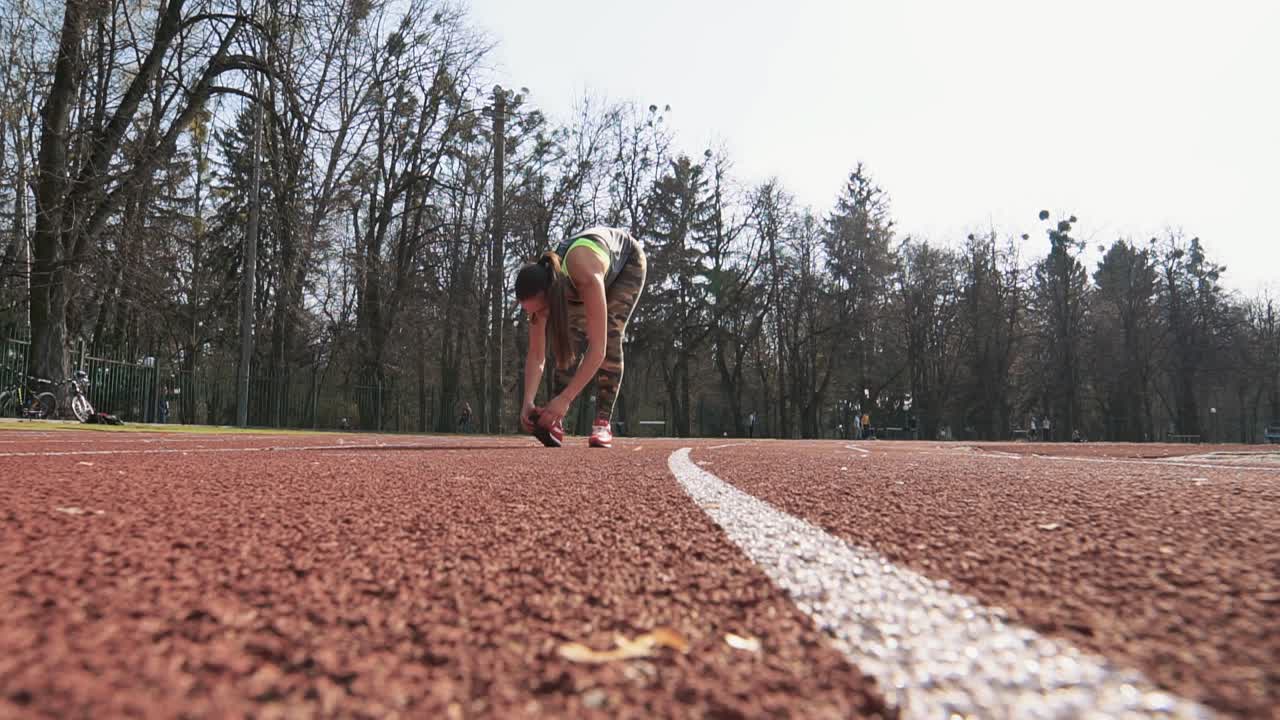 Young woman is stretching her legs after running. Summer outdoors training.
