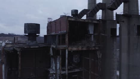 Drone-reveal-shot-of-an-abandoned-factory-in-a-industrial-zone-next-to-a-river