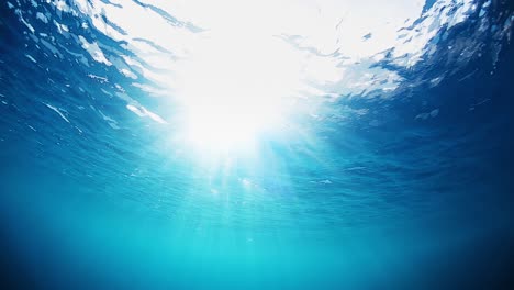 wave underwater, loop. sea surface underwater view. seamlessly loopable clip of the water surface with sun flare