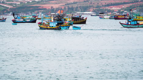 Colorful-Vietnamese-fishing-boat-leaving-harbor-on-calm-ocean-water,-static-view
