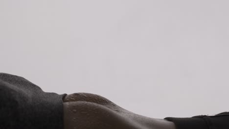 isolated close up of a woman doing stomach crunches and sweat beads forming on her stomach muscles