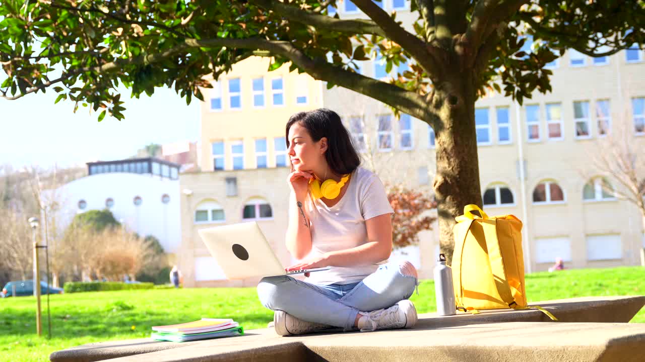 Student using laptop in park