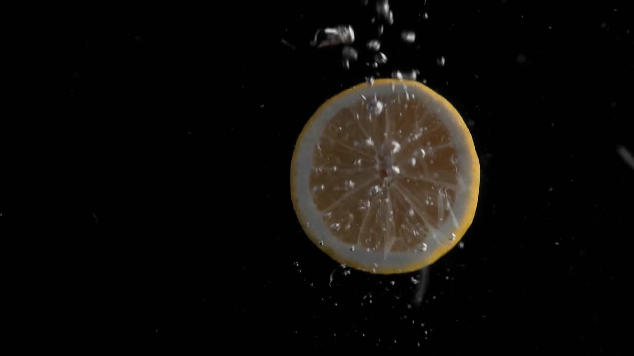 Lemon Falling into Water Super Slowmotion, Black Background, lots of Air Bubbles, 4k240fps