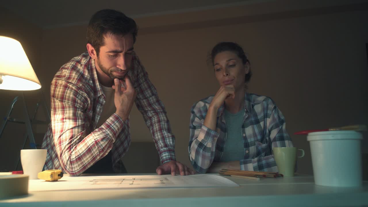 pareja comprobando el proyecto de su nueva casa