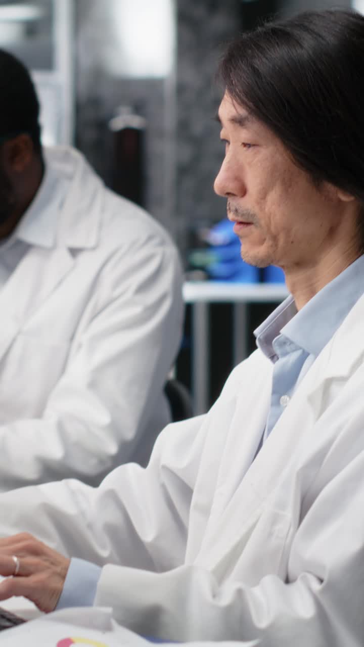 Vertical video Senior lab engineer using computer application for DNA data analysis