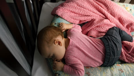 Baby-girl-sleeping-on-bed-in-bedroom