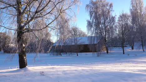 雪地景觀和舊農場建築在陽光明<unk>但有風的一天