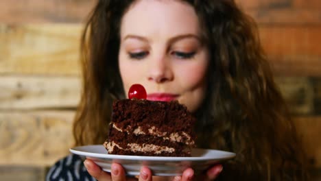 retrato de una cliente femenina sosteniendo un plato con pastel