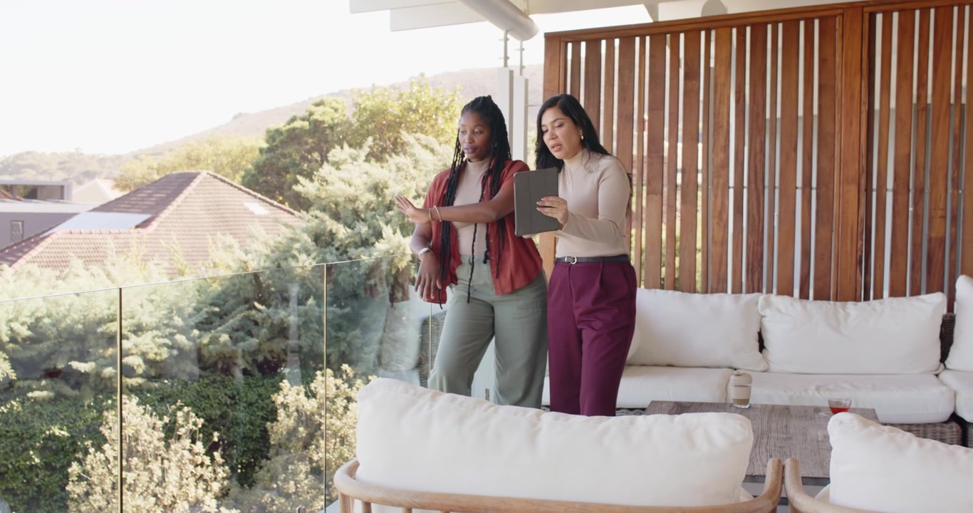 Donne diverse che escono sul balcone, consultano un tablet, indicano il paesaggio e controllano l'orologio da polso.