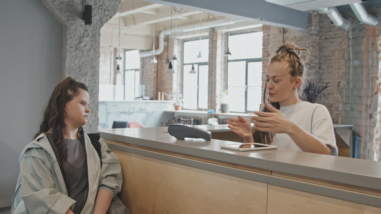 Young Woman With Down Syndrome Paying For Yoga Classes At Reception
