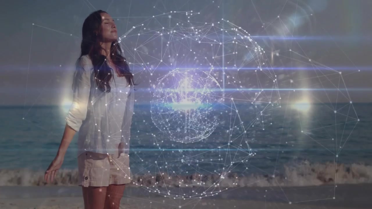 Mujer de pie en la playa cerrando los ojos y extendiendo los brazos, activando una esfera 3D giratoria que muestra tecnología.