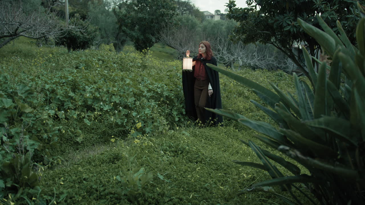 mujer camina misteriosamente entre las plantas y árboles del bosque con una linterna
