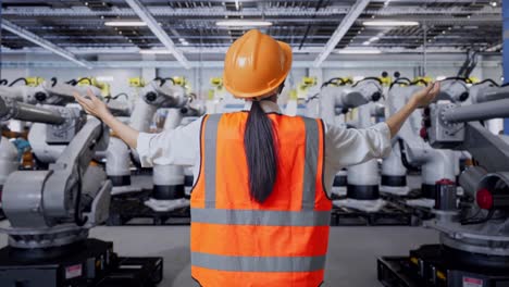 ingeniero observando robots industriales en una fábrica