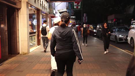 people walking along a busy city street