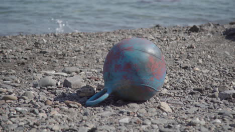 marine garbage buoy washed ashore on beach, human litter impact