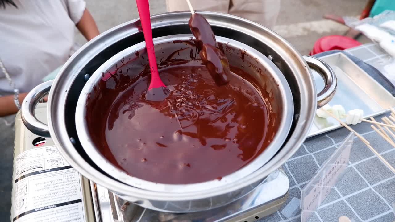 Intingere cibo nella fonduta di cioccolato