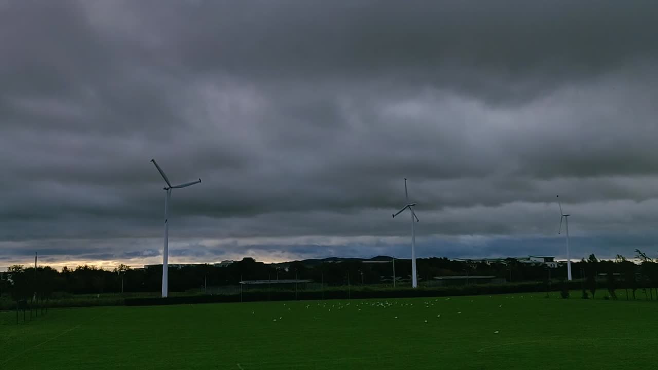 Dark Heavy Clouds Time lapse over a park with birds and  Windmill