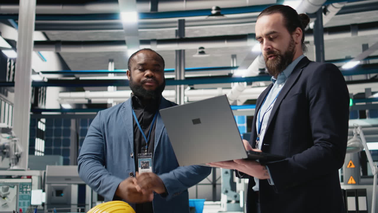 Engineers collaborating on project blueprints in industrial setting