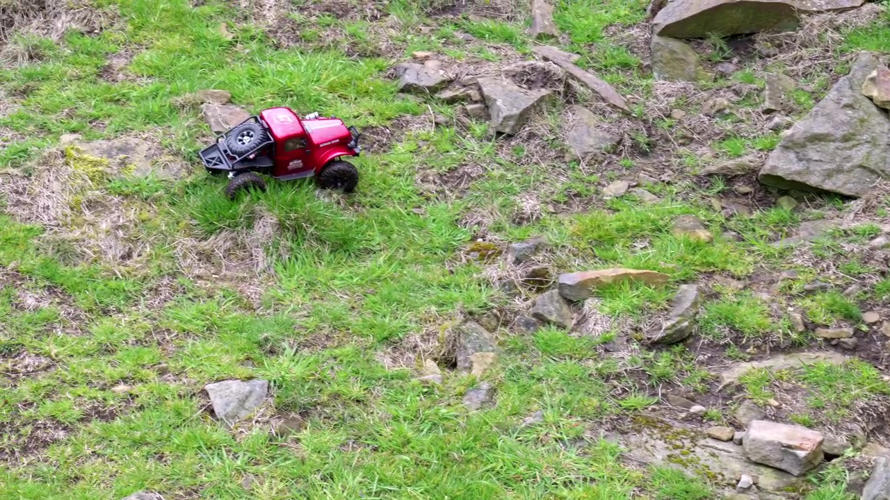 Giovane ragazzo all'aperto sulla brughiera che gioca con la sua auto RC, camion e 4x4.
