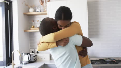 african american couple shares a warm embrace, hugging in a kitchen