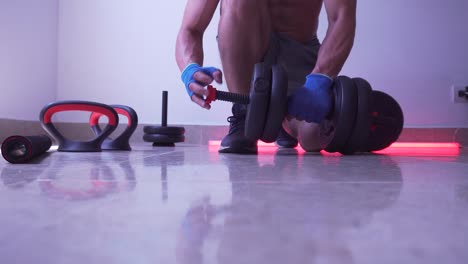 man disassembling weights after weightlifting session