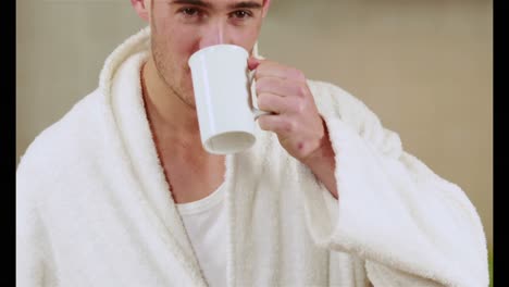 handsome man drinking coffee in bath robe