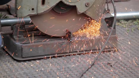 handyman cutting iron using circular saw machine in outdoor close up slow motion