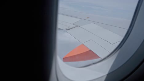 high altitude view over airplane wing from window seat, aviation