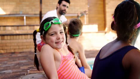 Niña-Sonriente-Sentada-Cerca-De-La-Piscina