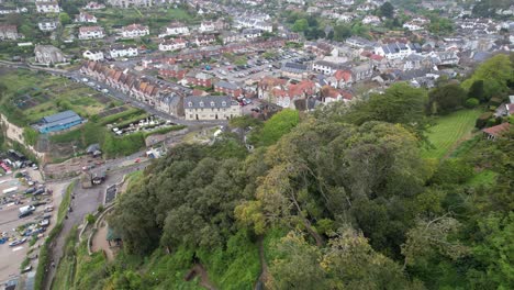 Beer-fishing-village-and-beach-Devon-England-drone-aerial-reveal-over-tree-lined-cliffs