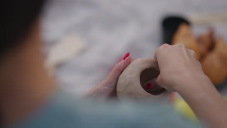 mujeres esculpen de arcilla en la naturaleza al aire libre en el parque. creatividad aficiones generales clases grupales de mujeres entrenamiento en modelado de arcilla. primer plano